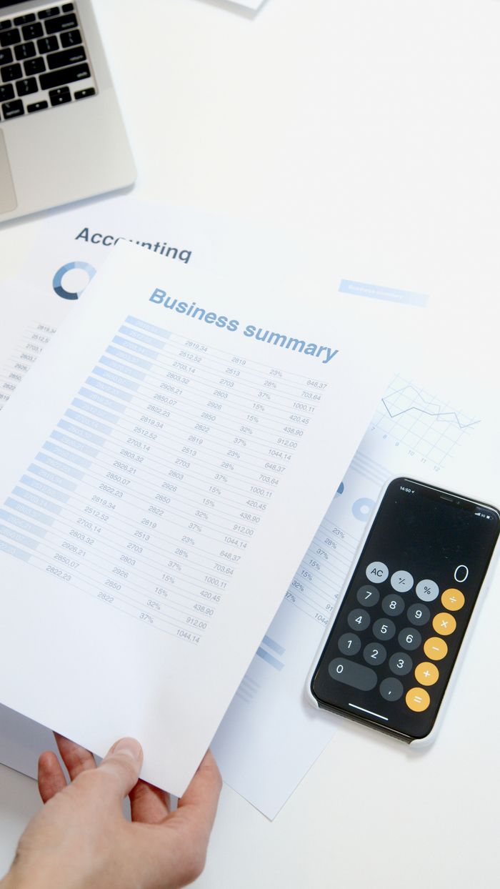 gallery-3 Business summary sheet with a calculator on a desk for financial analysis.